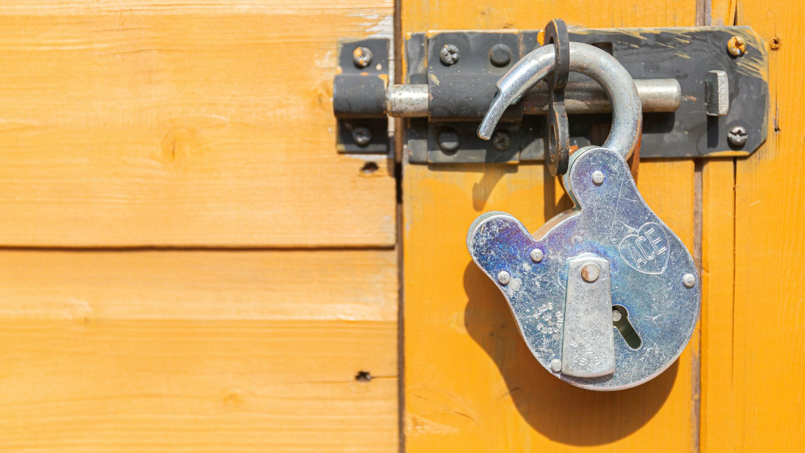 Cadenas fermant le verrou d’une porte en bois : la rupture du contrat par l’entreprise fournisseur