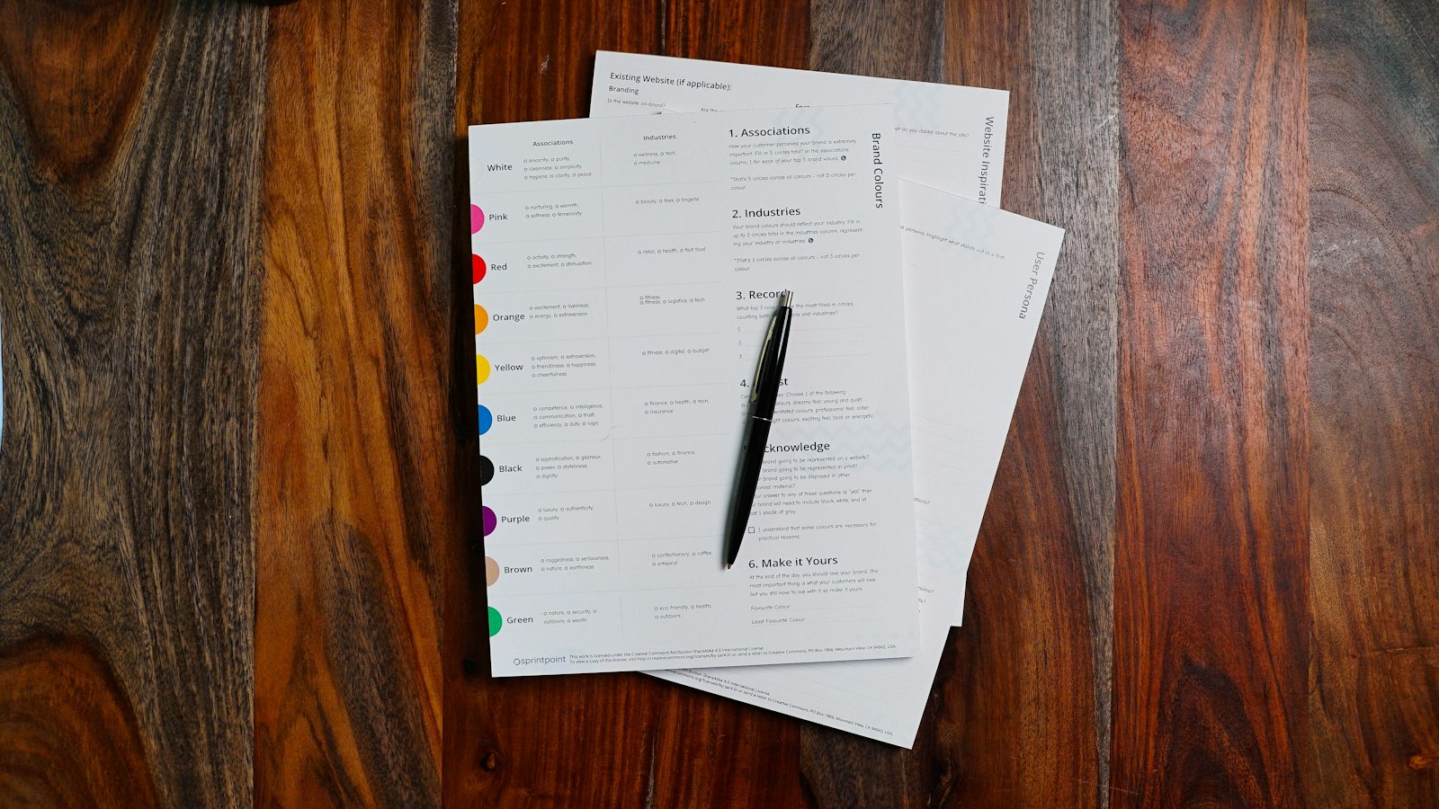 Documents et stylo posés sur une table en bois : le statut de gérant de succursale et le contrat de travail