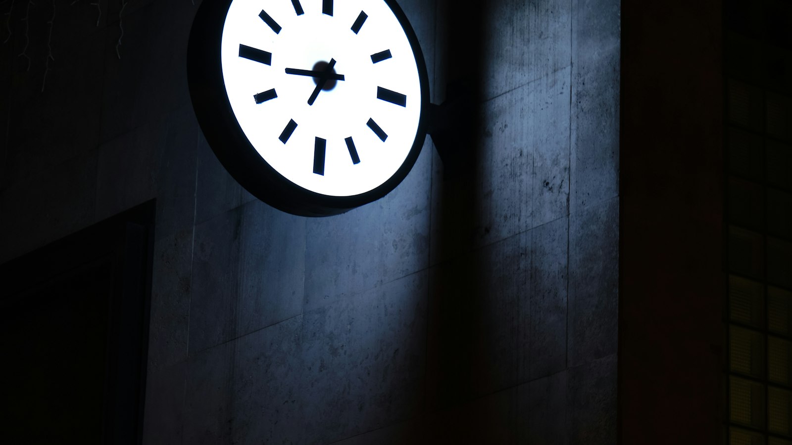 Horloge murale sans chiffres sur un mur de béton : l'aménagement du temps de travail dans l'officine