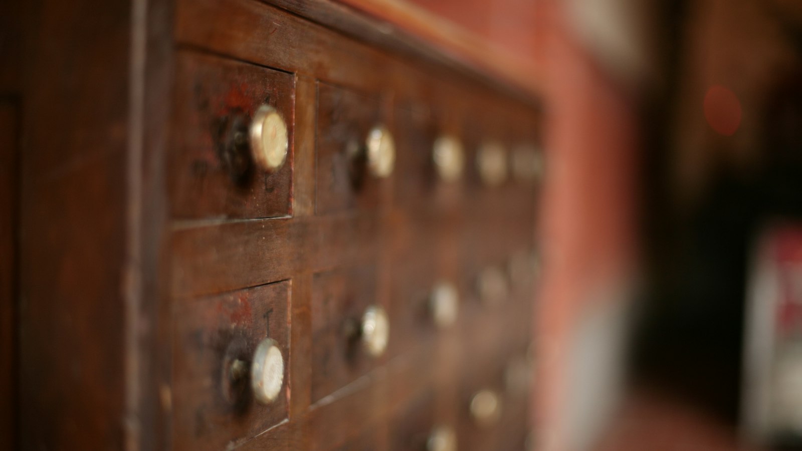 Ancienne armoire en bois à nombreux petits tiroirs : les manquements à la réglementation pharmaceutique par le salarié de l'officine
