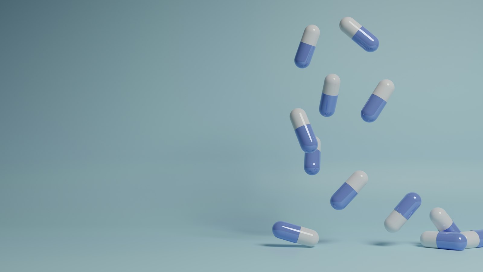 Gélules bleues et blanches en chute sur fond uni : les questions fréquentes des pharmacies d'officine