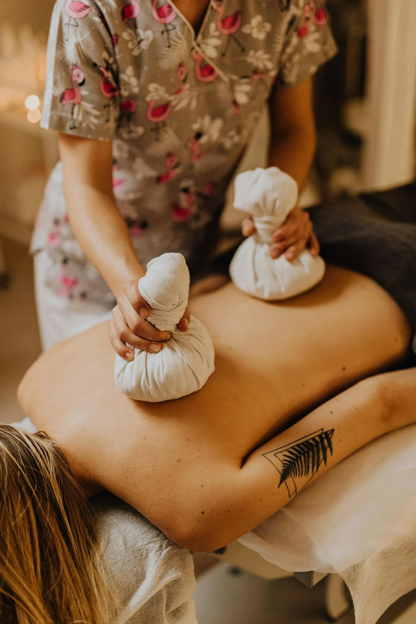 Therapist using herbal compress on back