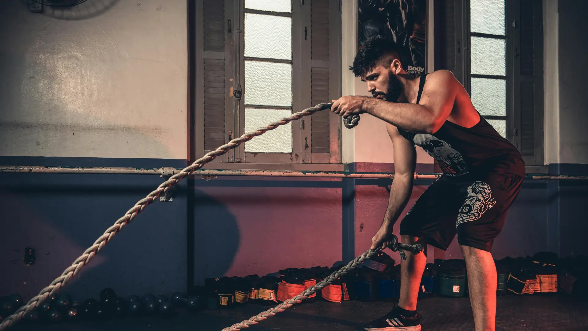 a member using battle ropes inside the gym