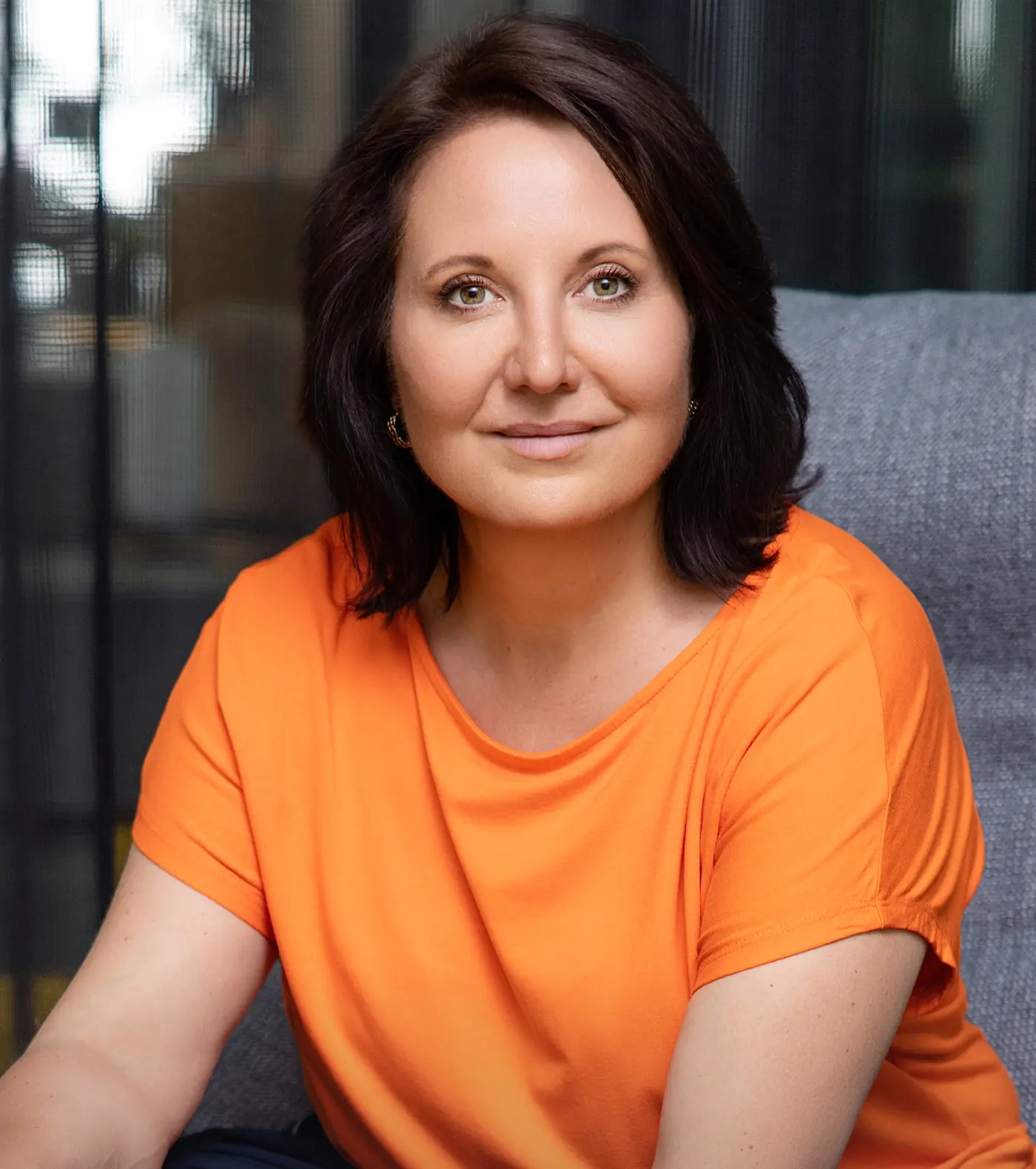 Marion Mossmann Schwarz, Expertin für Lernarchitektur und Akademiestrategie, in orangefarbenem Oberteil.