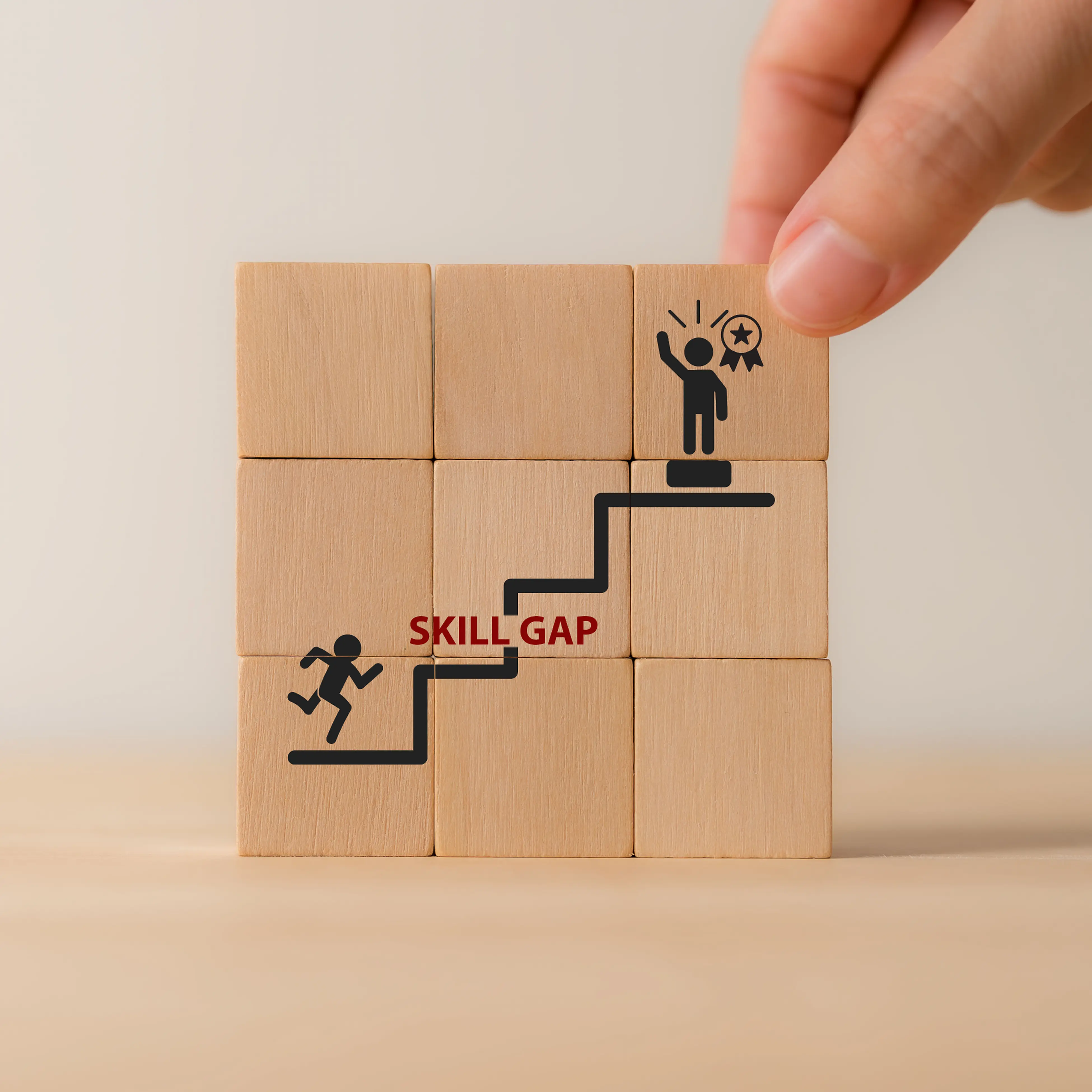 Holzbausteine mit Skill-Gap-Symbol zeigen eine Kompetenzlücke, passend zu Lernarchitektur und gezieltem Kompetenzaufbau im Unternehmen.