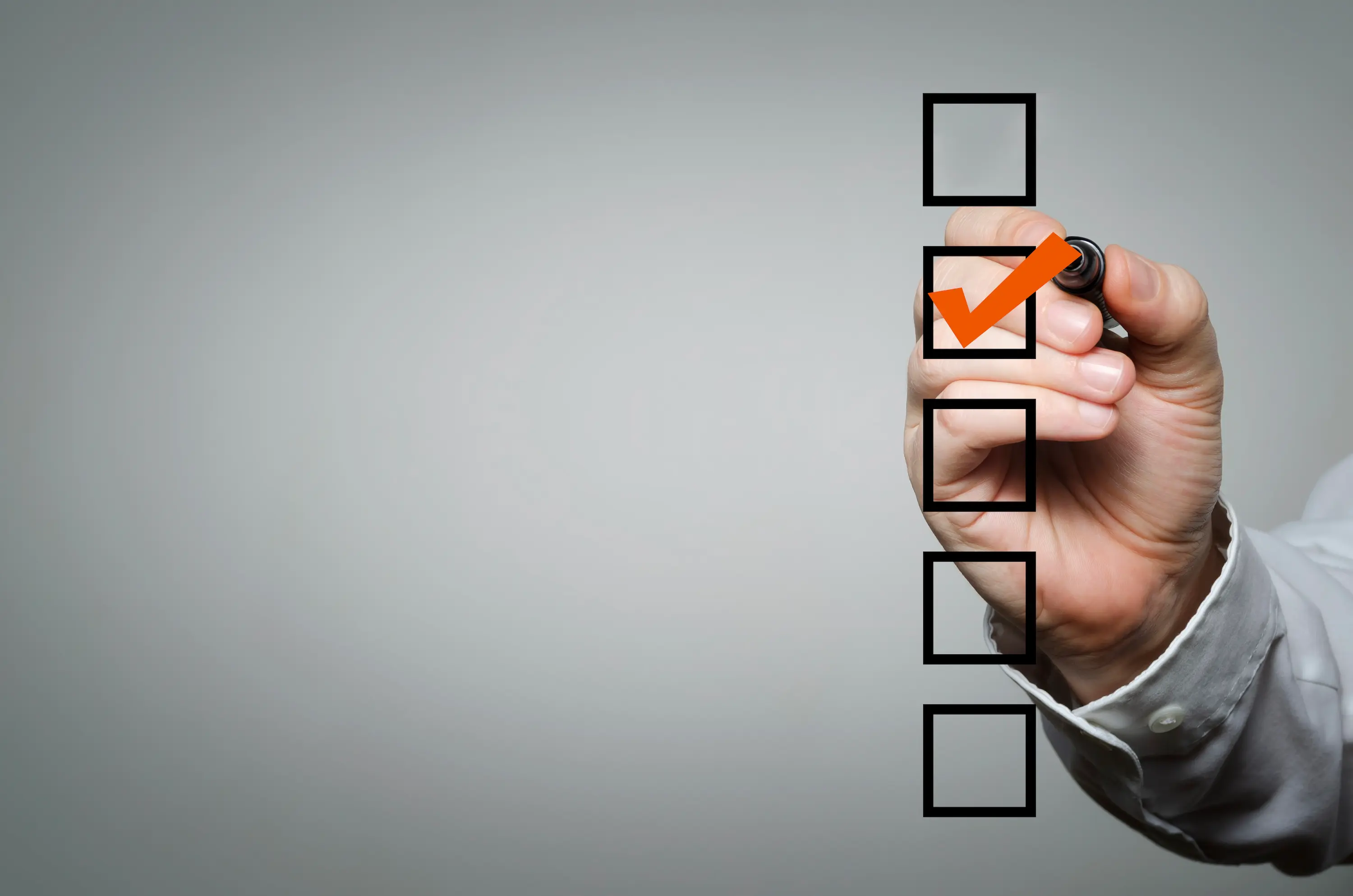 Hand markiert eine Checkbox auf einer Checkliste, passend zu strukturierten Leistungspaketen und klaren nächsten Schritten.
