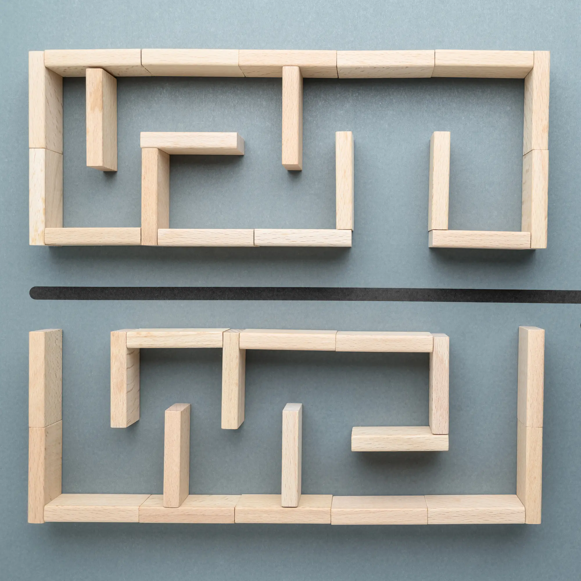 Holzbausteine formen ein Labyrinth als Symbol für Systemdenken und strukturierte Lösungswege.