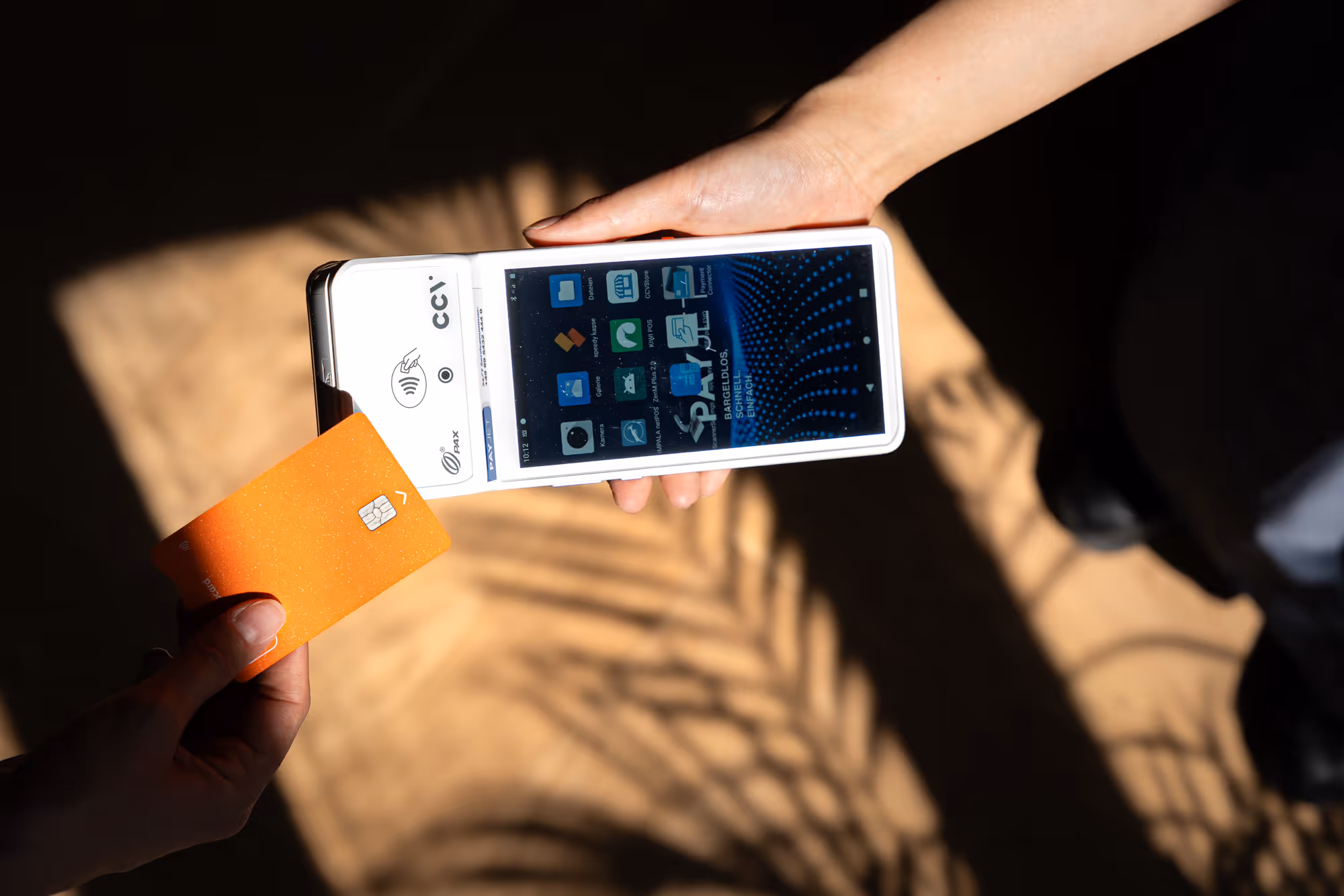 Kunde hält Karte zum kontaktlosen Bezahlen an mobiles Kartenterminal