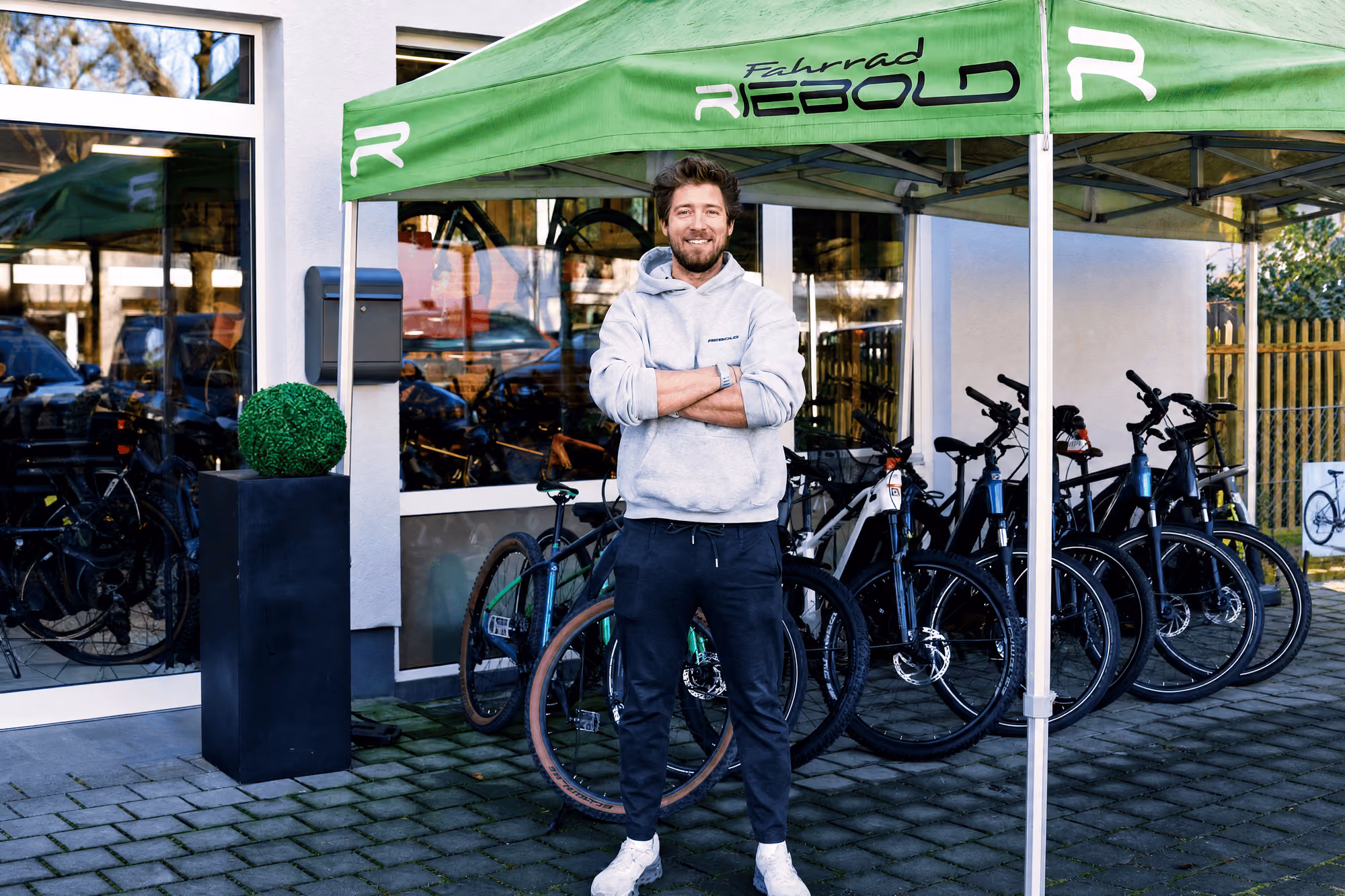 Händler vor dem Fahrradgeschäft Rebold mit ausgestellten E-Bikes