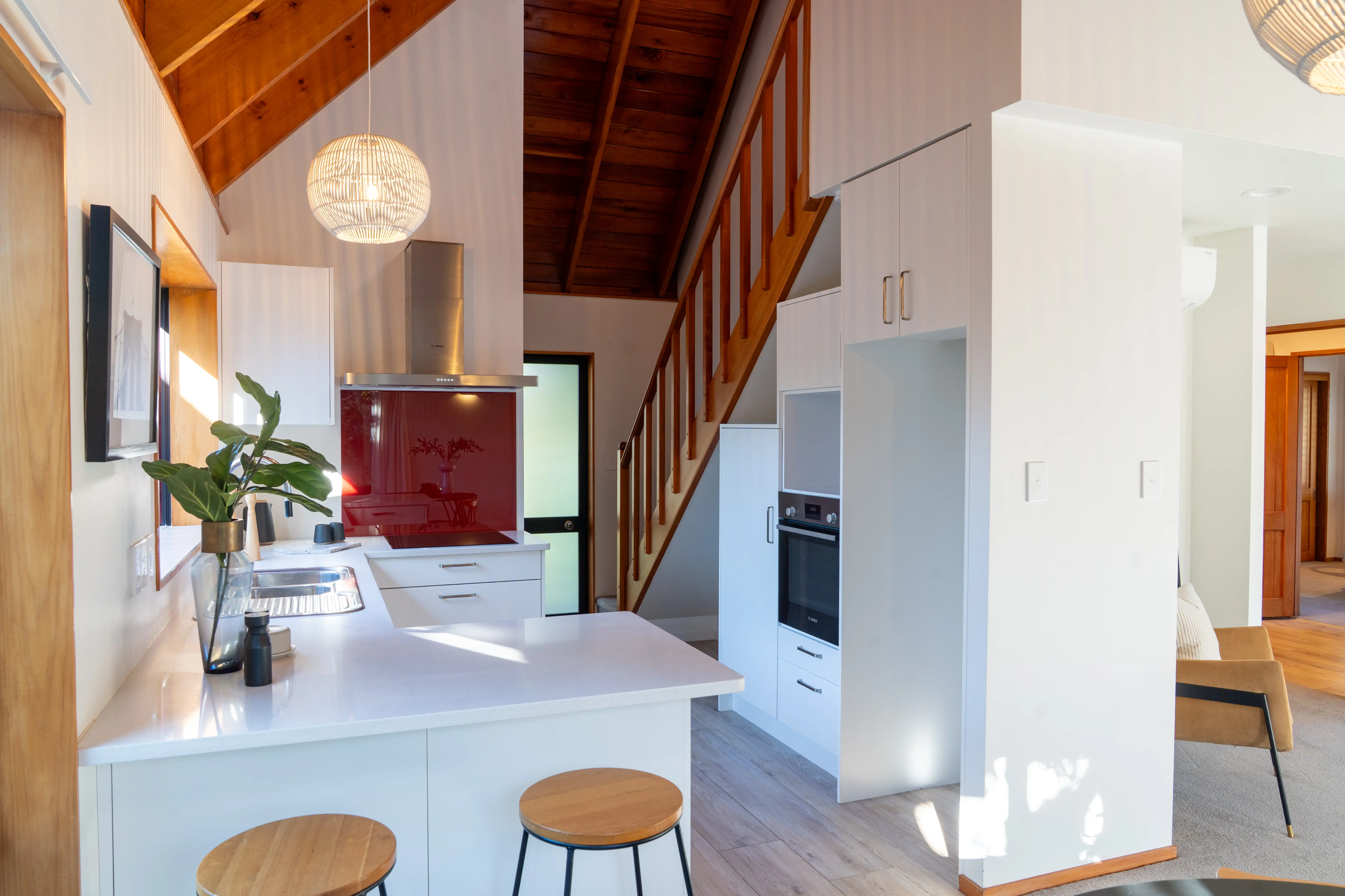 The kitchen in a villa, with an island bench and seating.