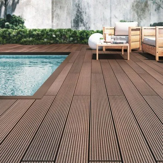 Swimming pool area with wooden deck flooring and modern outdoor seating with cushions and a coffee table.
