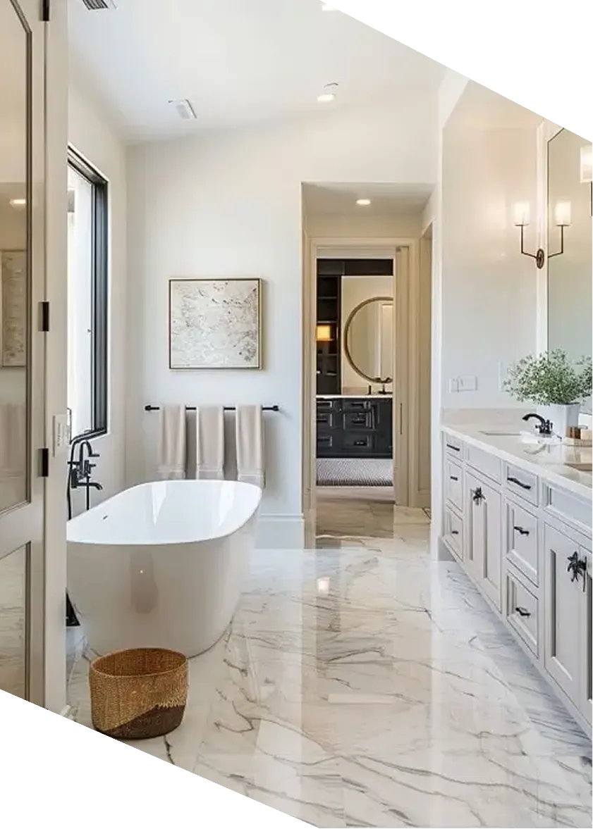 Modern bathroom with freestanding white tub, marble floor, double vanity, and wall art over towel rack.