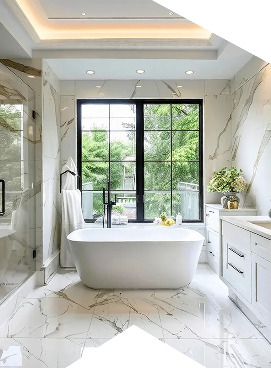 Bright modern bathroom with freestanding white bathtub, marble floor, large window, and white cabinetry.