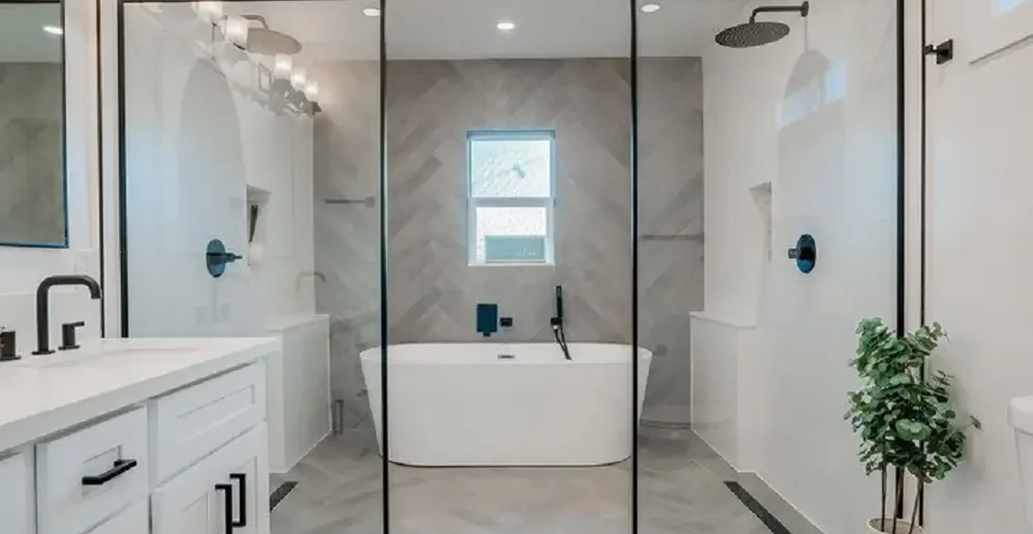 Modern bathroom with freestanding white bathtub, glass shower enclosure, and black fixtures.