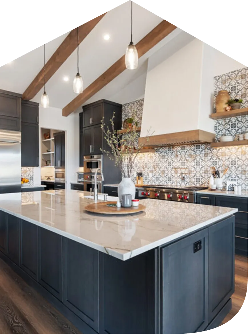 Modern kitchen with large marble island, dark cabinets, patterned tile backsplash, and wooden ceiling beams.