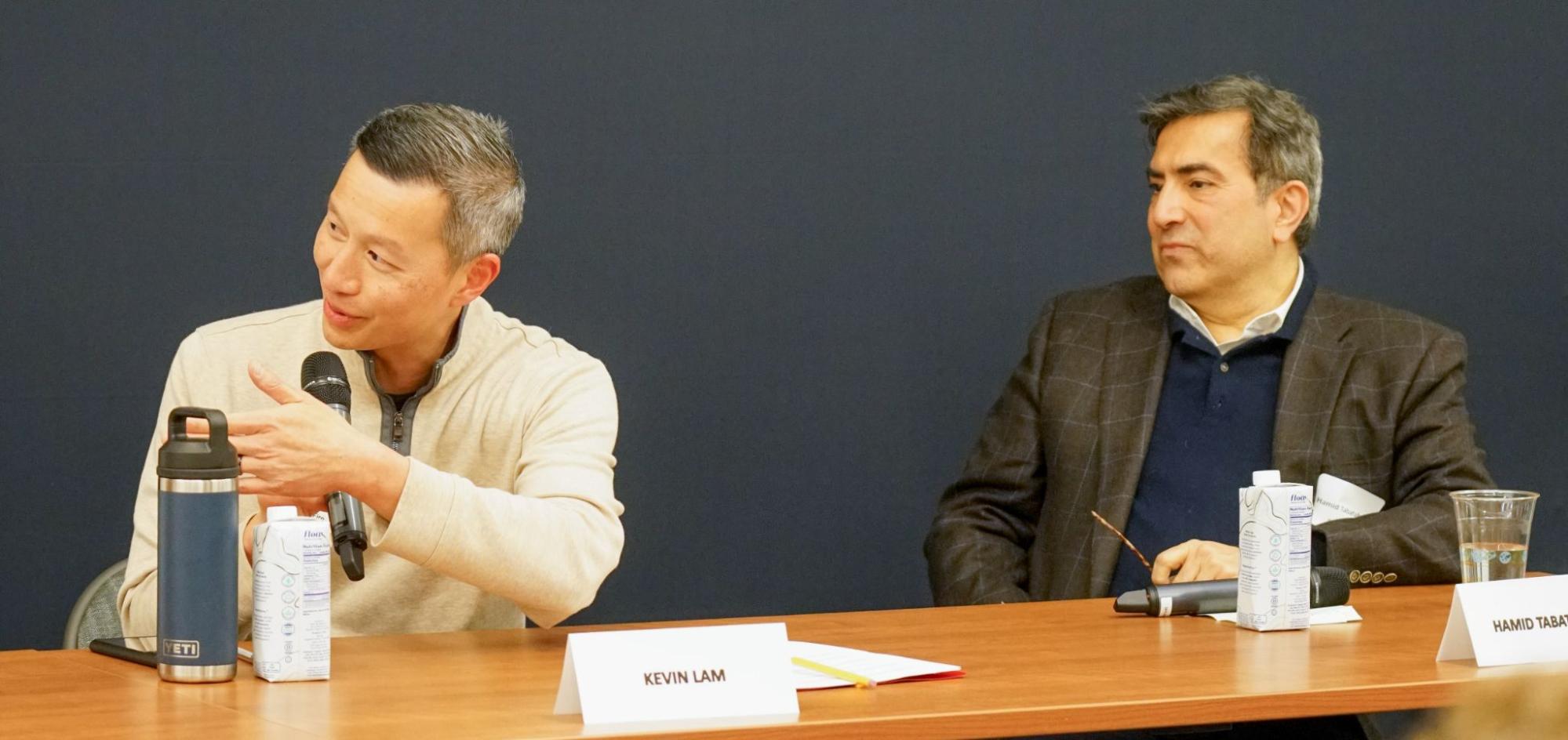 Two men sitting at a table: Kevin Lam and Hamid Tabatabaie