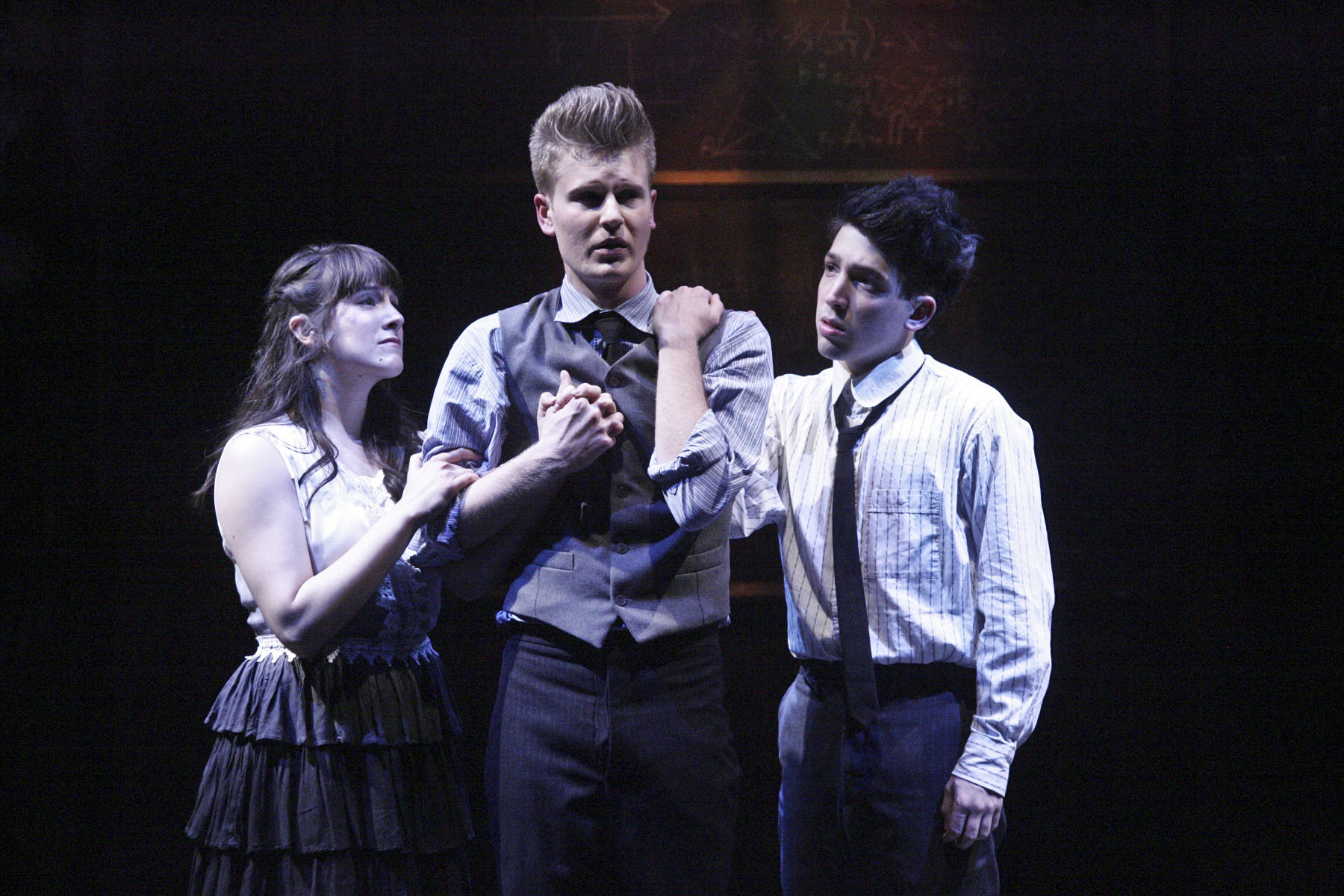 Three young people in period school clothing gather in an anguished moment in Spring Awakening.