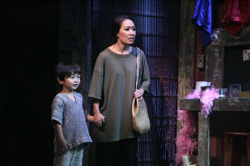 Kim stands beside her young son, Tam, in a scene from Miss Saigon.