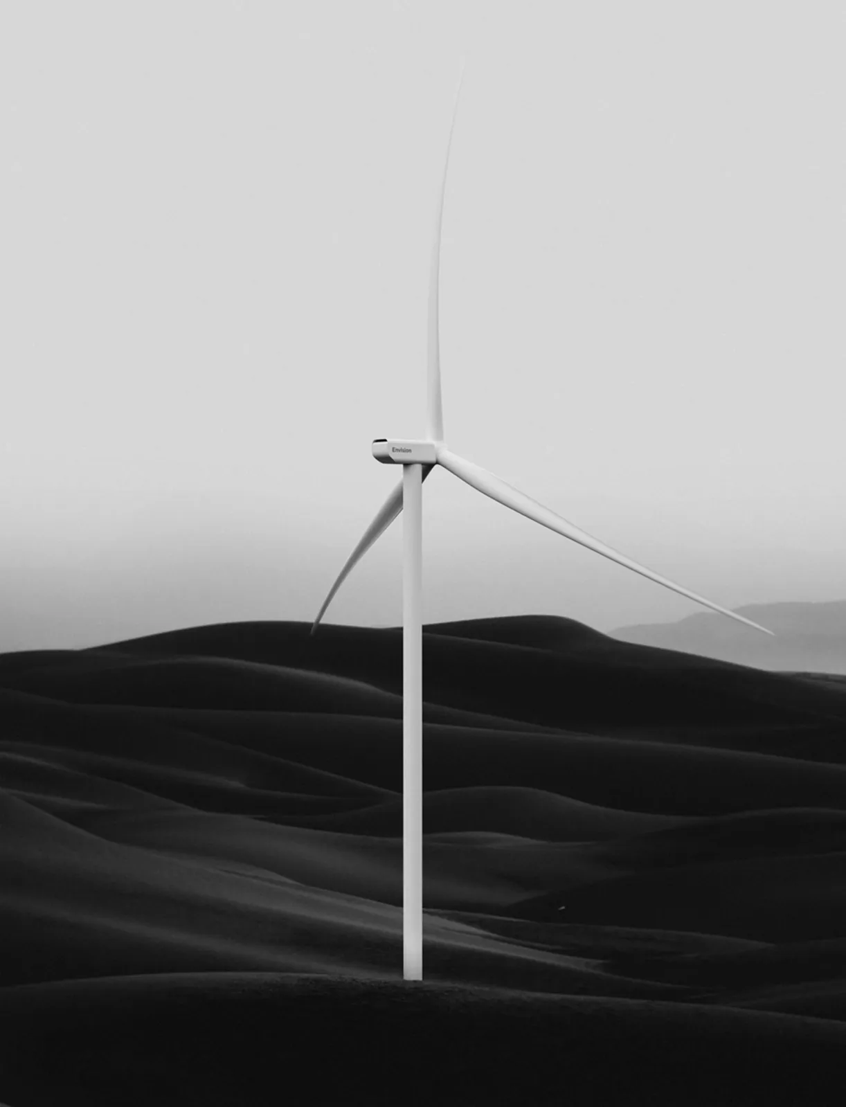 Wind turbine over dark hills