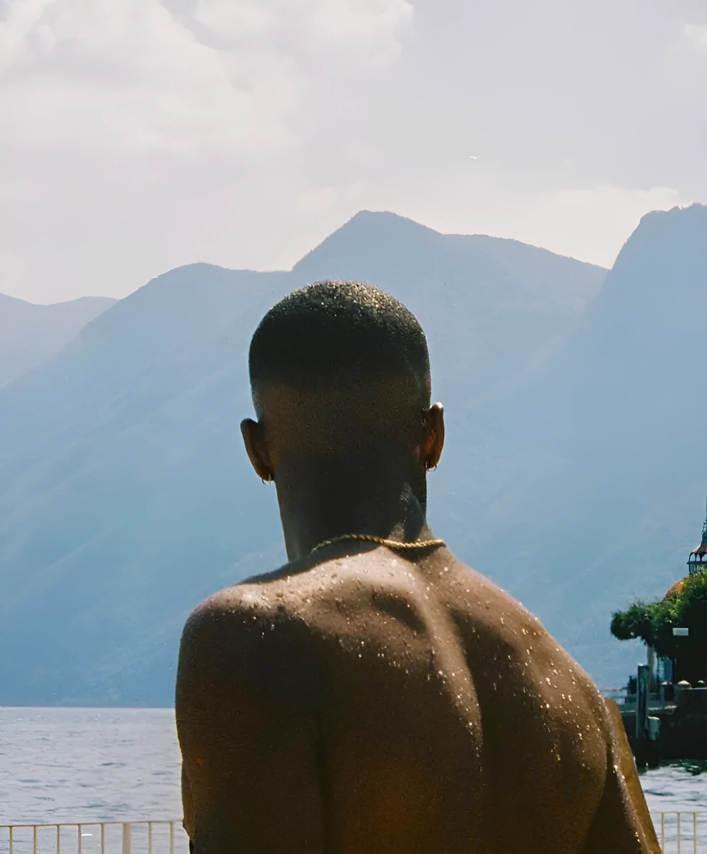 Man looking out over a lake and mountains