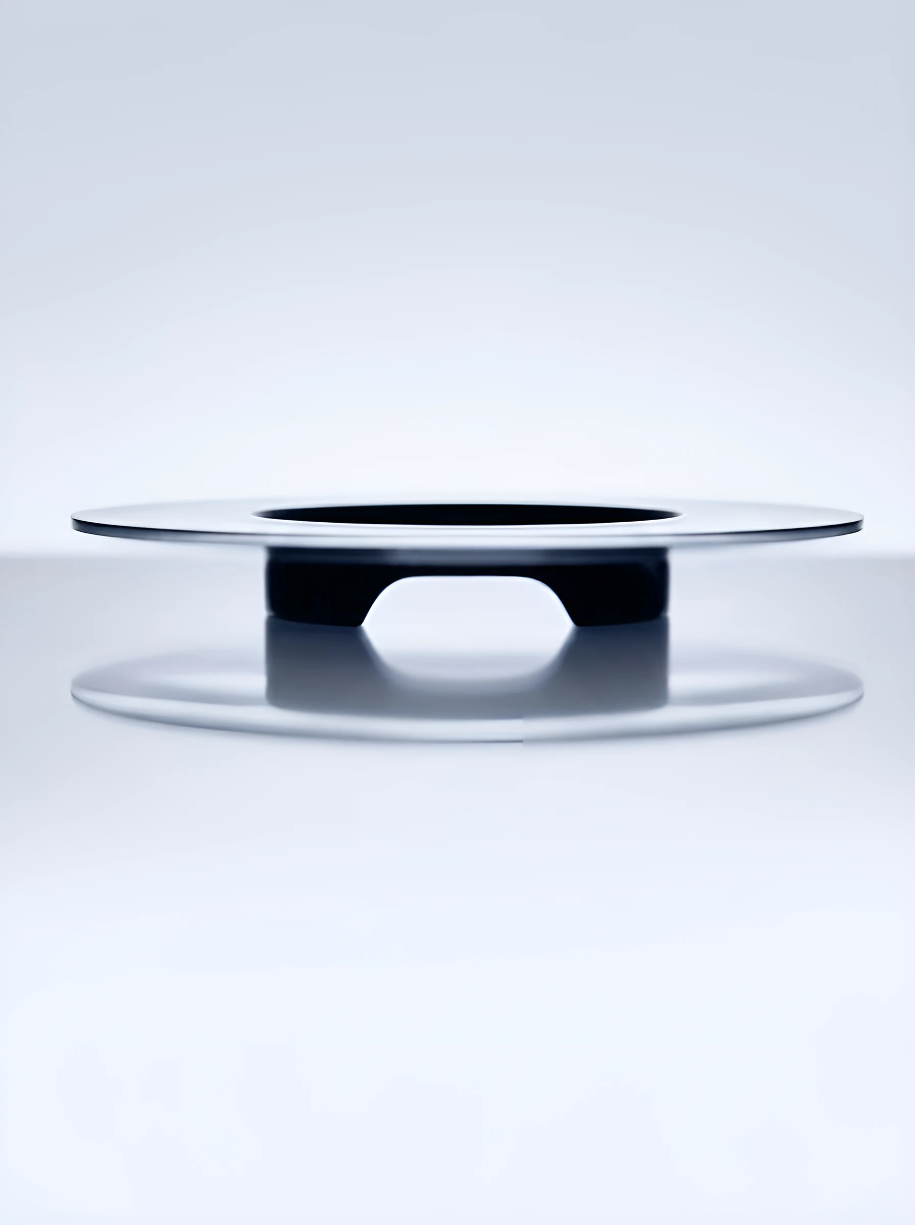A polished disc form floating on a pale background