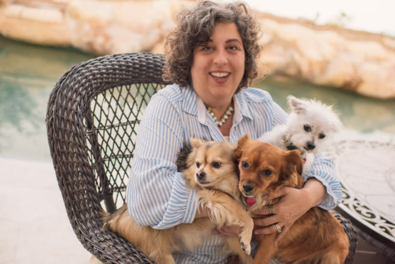 Kara on a chair with her dogs.