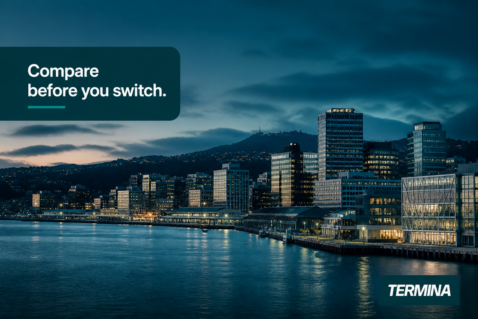 This image shows a nighttime view of Wellington's waterfront business district, highlighting a row of office buildings illuminated with interior lights reflecting on the calm water. The scene conveys a modern urban environment with hills in the background under a moody, cloudy sky. Overlay text on the left side reads 'Compare before you switch,' suggesting an invitation to evaluate options before changing services. The Termina logo is visible in the lower right corner, indicating that this image is used for promotional or informational content related to Termina's electricity plans for businesses in Wellington.