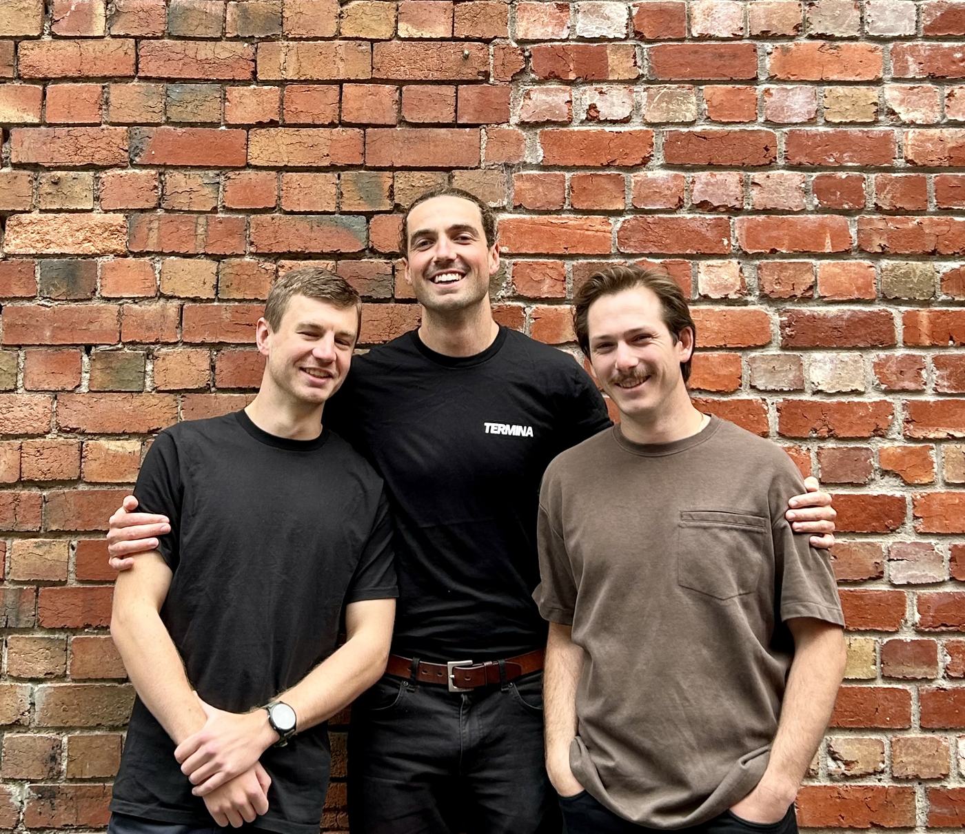 Termina’s three founders laughing in front of a brick wall
