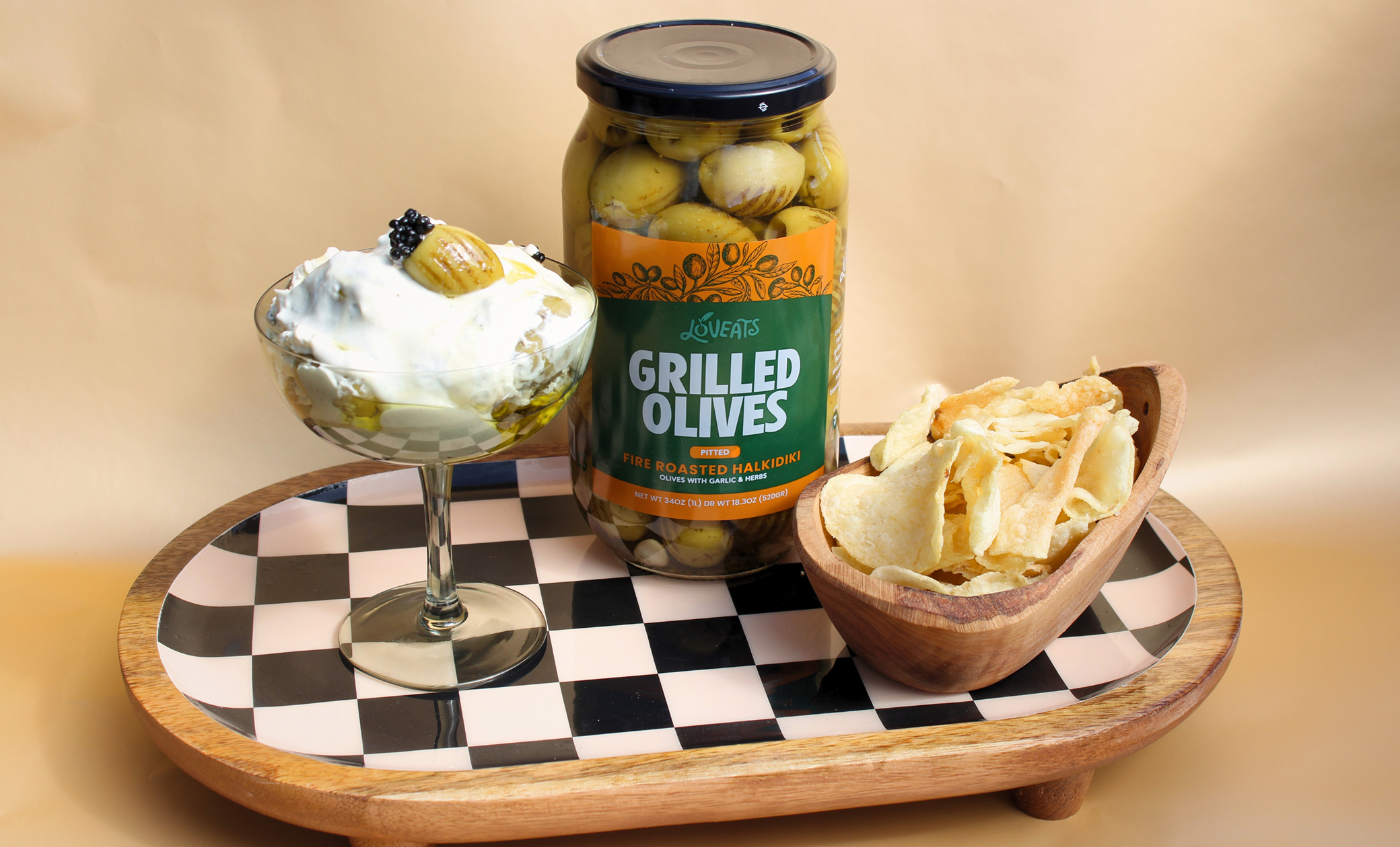 “Loveats gourmet dip jar with pita chips and creamy dip on a checkered serving tray.”