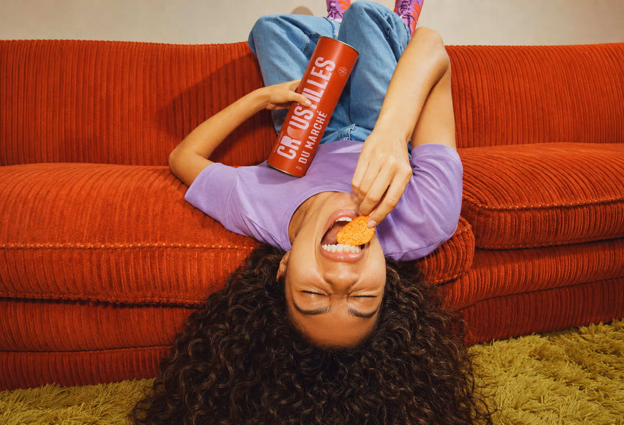 Alt text: Lifestyle mockup featuring MPM artisanal chip packaging on a red couch with vibrant editorial styling.  Credit: Inspired by editorial advertising photography and digitally modified for student project use.