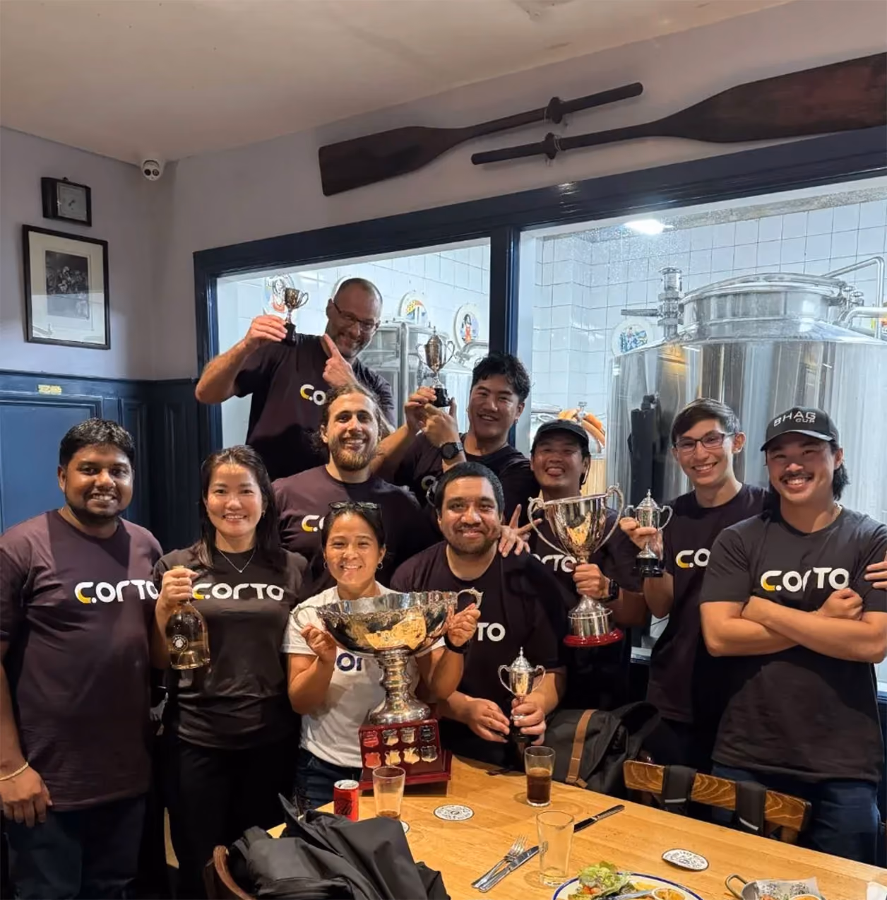 CORTO team celebrating BHAG Cup trophies at a brewery venue.