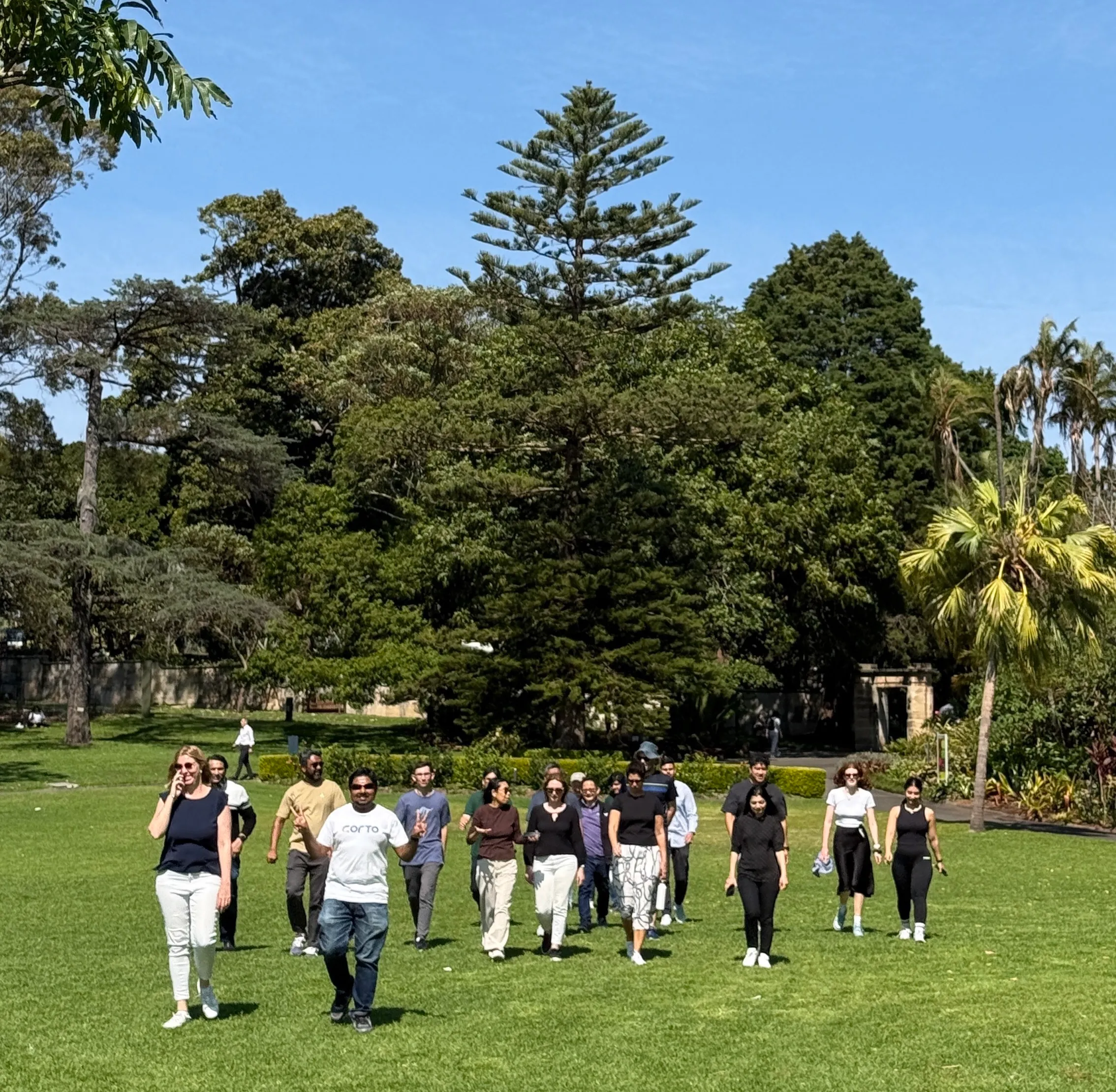 CORTO team walking together through a sunny park during a company team day.