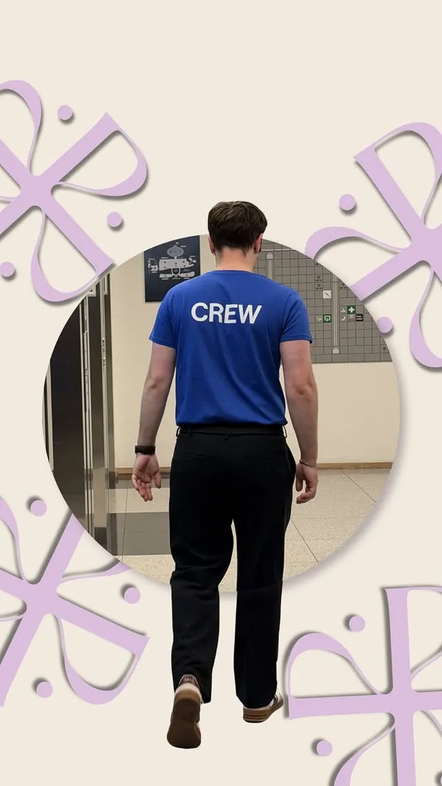 Homme de dos portant un t-shirt bleu avec le mot CREW marchant dans un couloir intérieur.