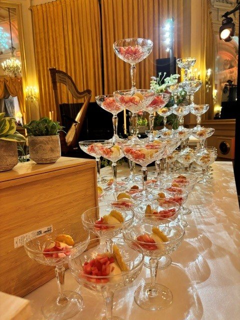 Tiered champagne coupe display garnished with fresh fruit for a corporate themed evening