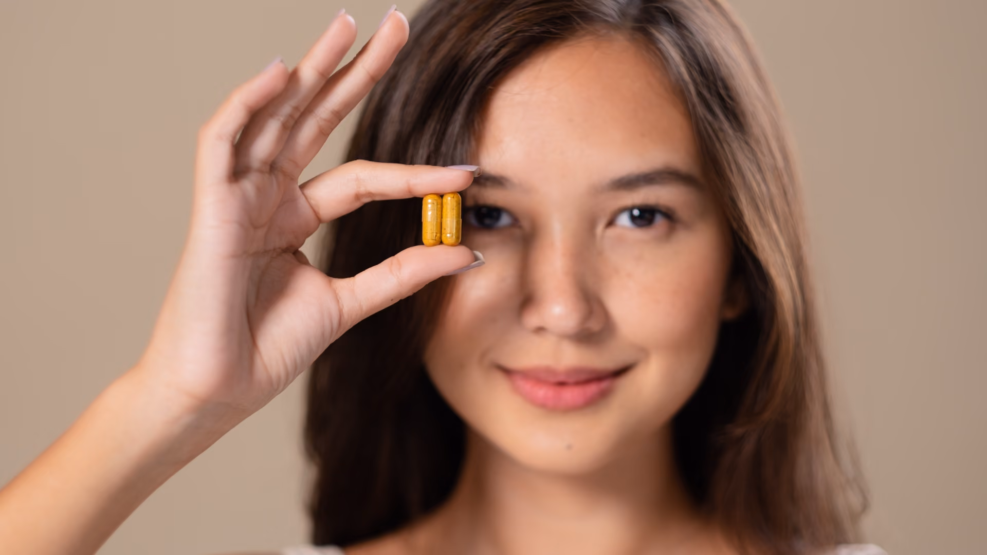 Woman holding natural supplement capsules, representing holistic health support