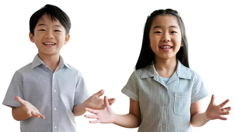 Smiling boy and girl with outstretched hands wearing collared shirts on white background.
