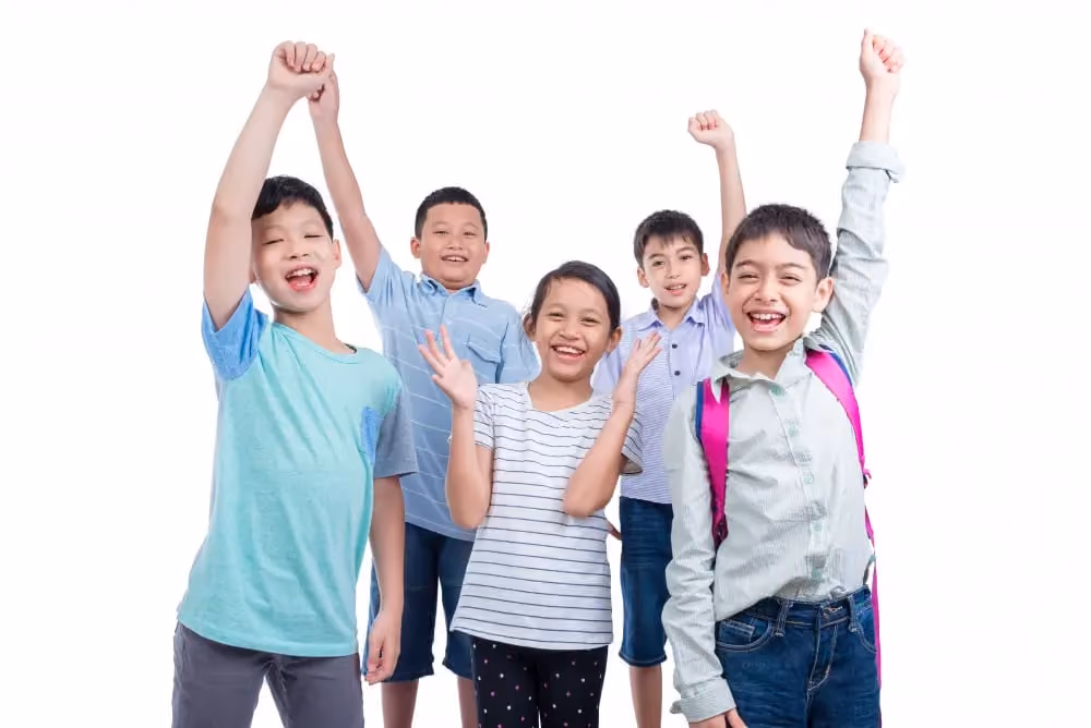 Five happy children smiling with arms raised, one wearing a backpack and standing in front.