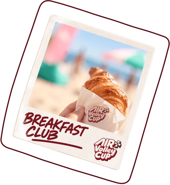 Polaroid-style photo of a hand holding a croissant wrapped in paper with the Air Volley Cup logo, with blurred beach umbrellas and people in the background, labeled 'Breakfast Club' and Air Volley Cup logo below.
