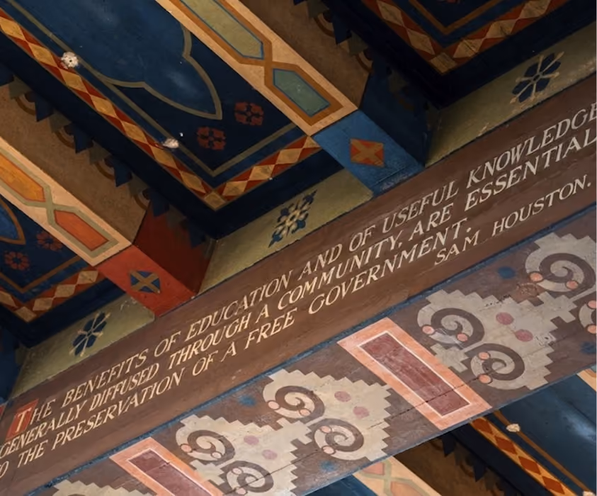 Decorative ceiling beams with a quote on education and government by Sam Houston.