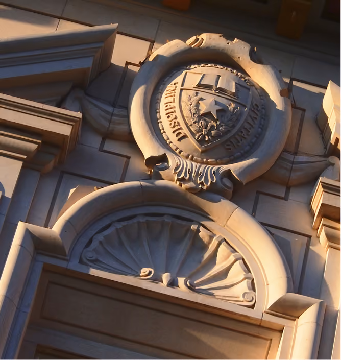 Decorative stone architectural detail featuring a shield with text and a star emblem on a building facade.