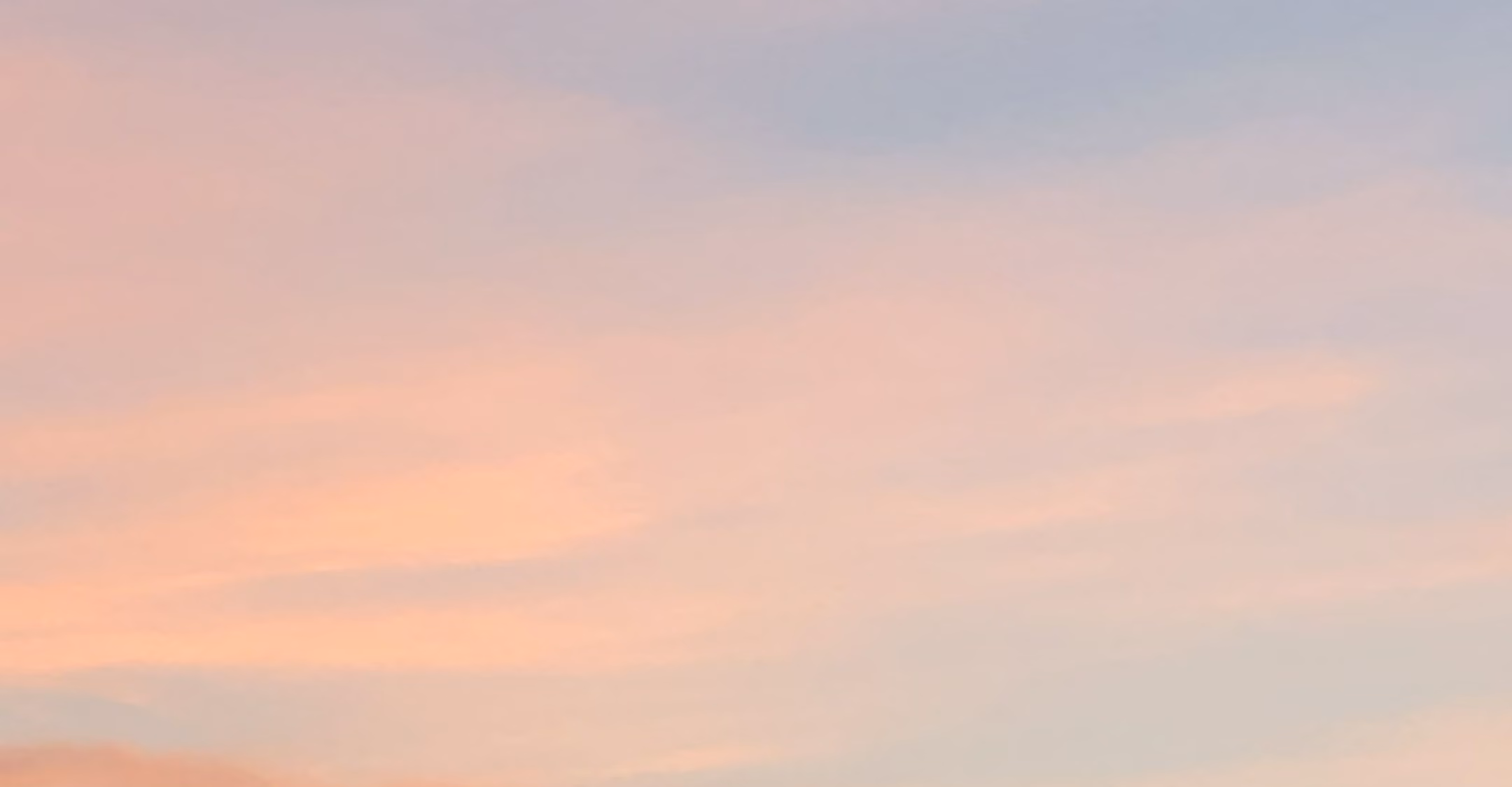 Soft pink and purple pastel sky with gentle cloud streaks during sunset.