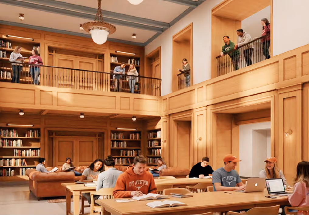 Students study, read, and chat in a spacious two-level library with wood paneling and bookshelves.
