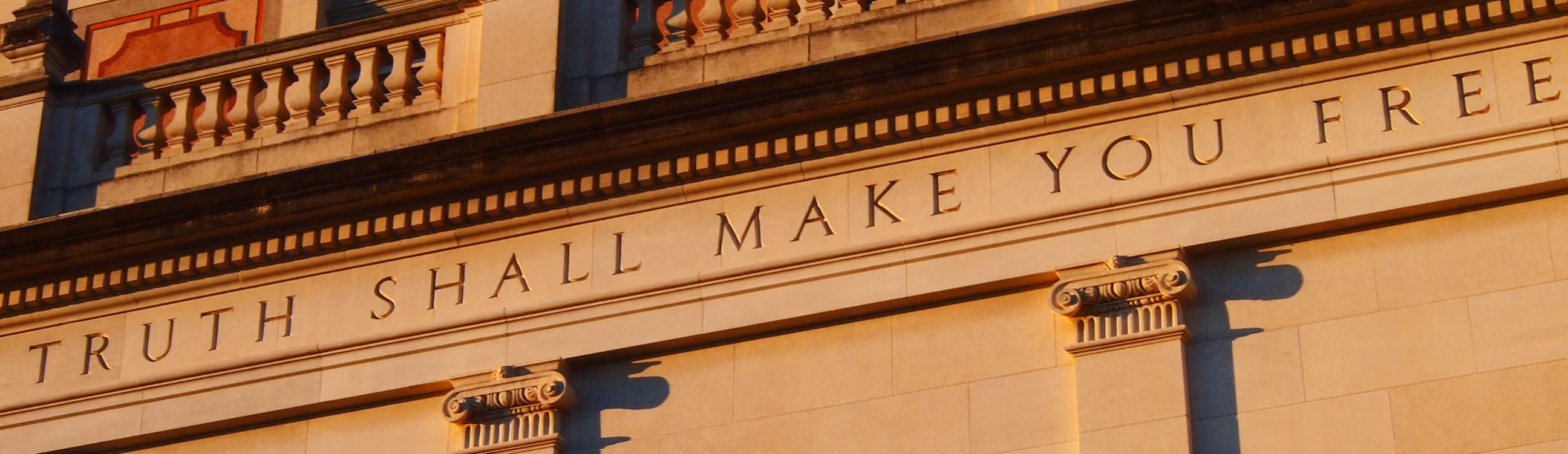 Building facade with the inscription "TRUTH SHALL MAKE YOU FREE" in capital letters.