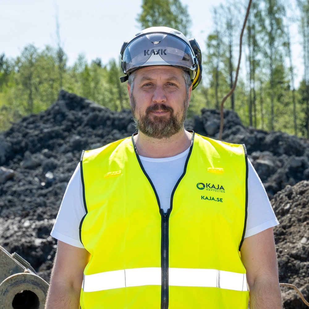 Porträtt på Fredrik Stake, som står framför schaktmassa i varselkläder.