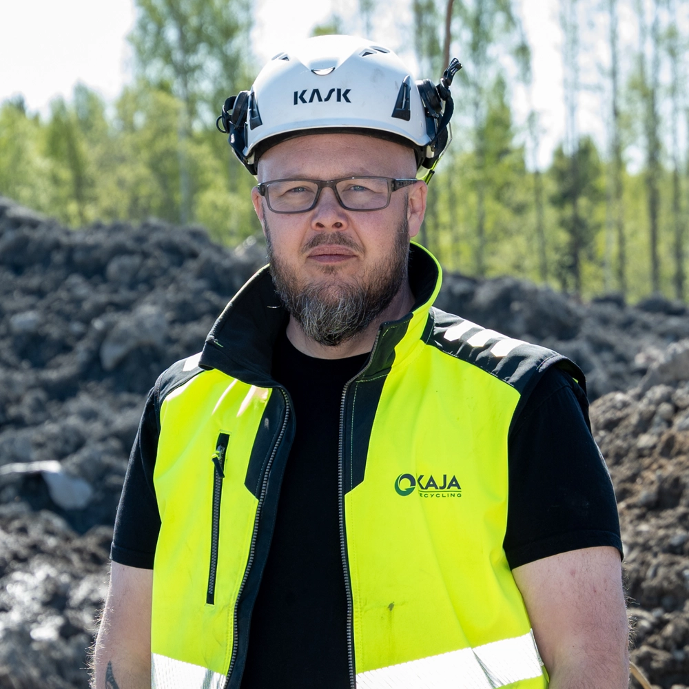 Porträtt på Jonas Olsson, som står framför schaktmassa i varselkläder.