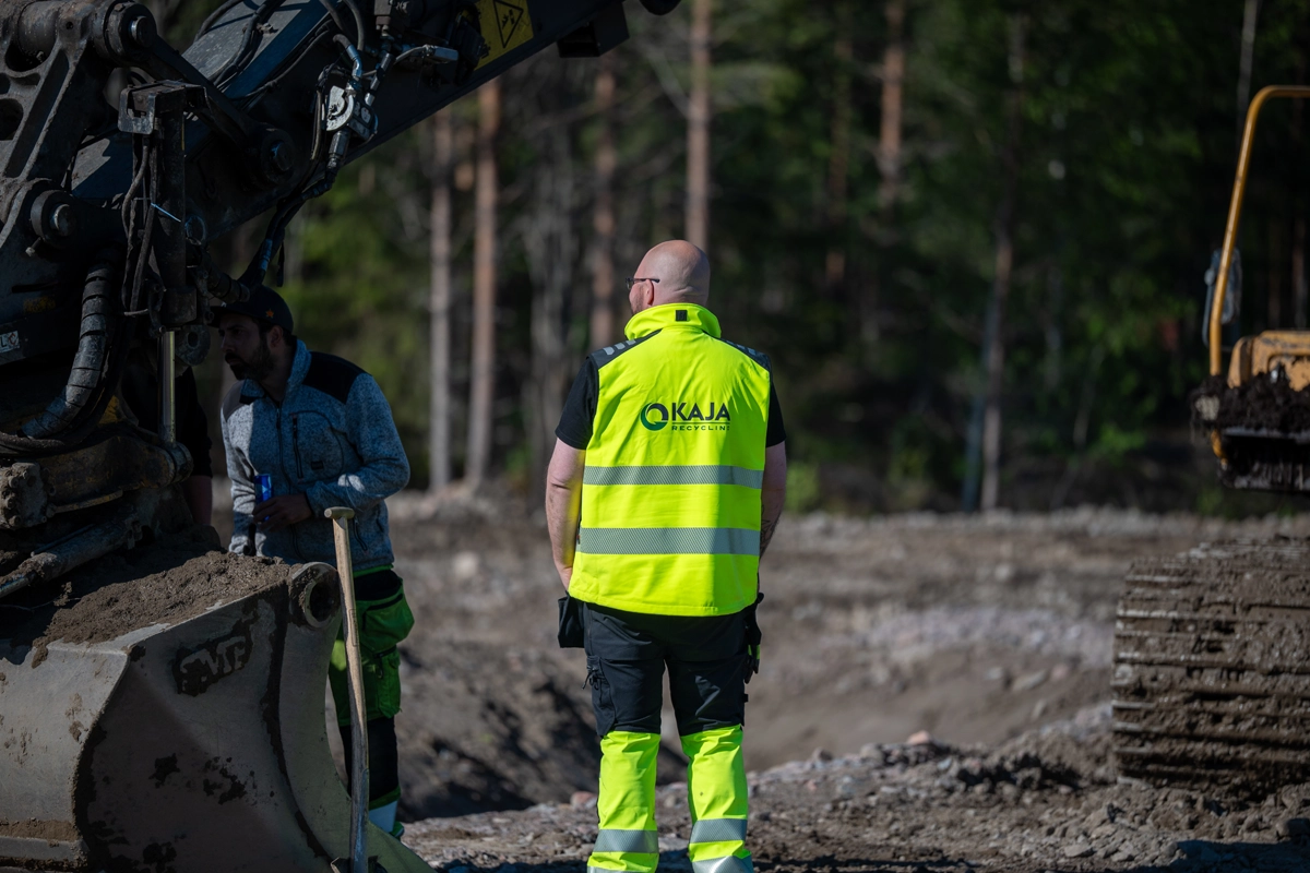 Medarbetare från KAJA Recycling i varselkläder på anläggningen i Sälgsjön.