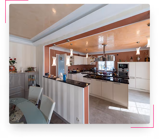 Moderne Küche mit weißen Schränken, schwarzen Arbeitsflächen und Esstisch mit Stühlen.
