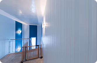 Flur mit weißen Wänden, Holzgeländer und blauer Wand mit Lichtakzenten in modernem Interieur.