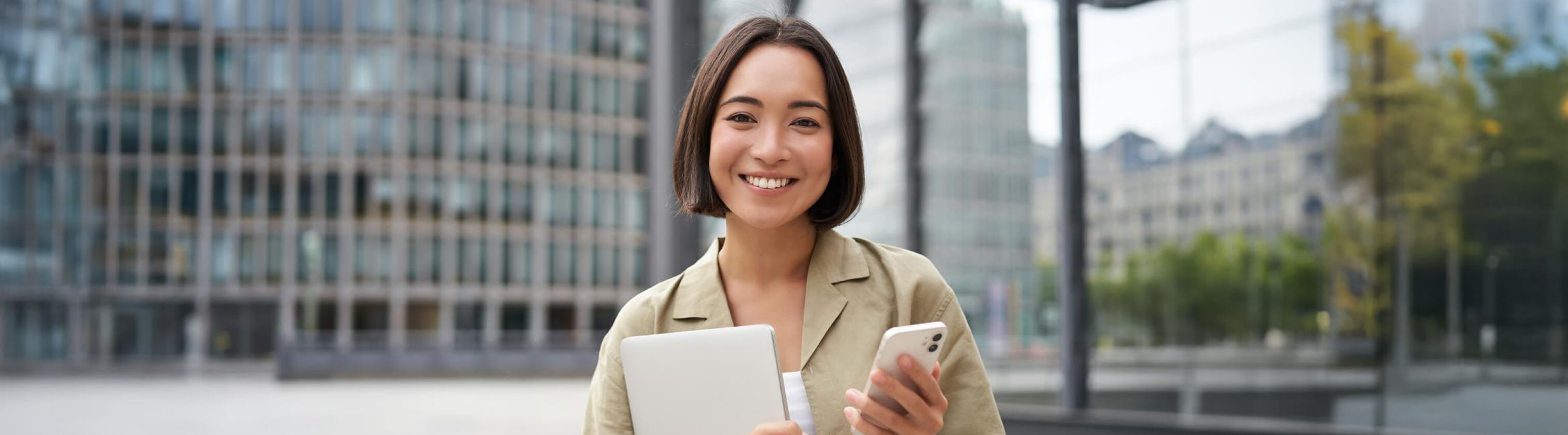 Happy woman with a mobile and some paper outsite