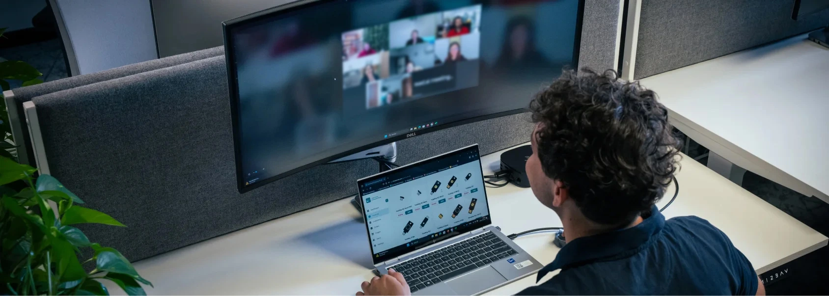 Office photo with a team member sitting in front of a laptop participating an online meeting